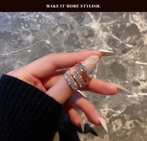 Detail showing gold-plated multi-layer spiral ring with micro-paved rhinestones on finger