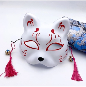 Close-up of Japanese fox mask with pink tassels and blue cherry blossom patterns