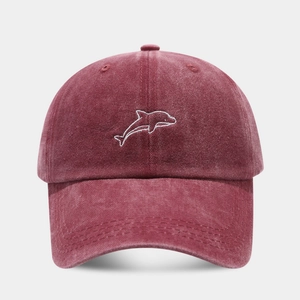 Close-up of a burgundy washed cotton baseball cap featuring white dolphin embroidery