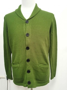 Detail view of olive green knit cardigan featuring shawl collar and black buttons