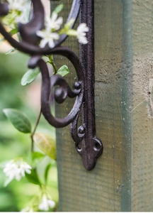 Detailed view of European vintage cast iron bracket with scroll pattern on wood