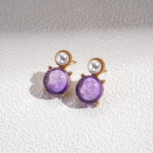Detailed macro view of vintage court style earrings with purple resin and faux pearls