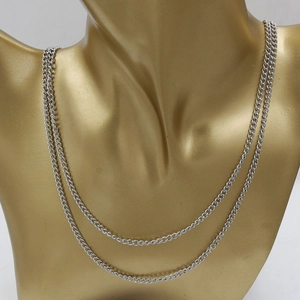 Macro detail of 3mm stainless steel curb chain necklace on golden model mannequin