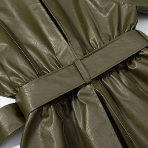 Close-up of dark green PU leather jacket showing belted waist and pleated details