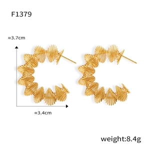 Détail de boucles d'oreilles en titane doré montrant la hauteur de 3,7 cm et la texture