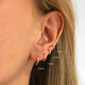 Minimalist gold hoop earring set featuring 5mm to 8mm sizes for multi-pierced ears