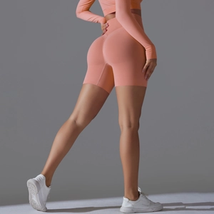 Close-up of high-waisted seamless orange yoga shorts with peach butt-lifting texture details