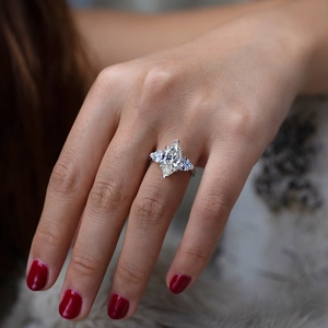 Close-up of a marquise cut silver ring worn on hand with red nails for engagement