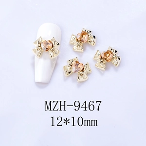 Detailed view of champagne heart crystal nail bow jewelry in 12x10mm size on a white nail tip