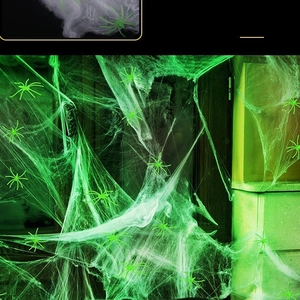 Luminous green Halloween spider web with plastic spiders for haunted house decor