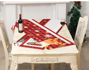 Detail view of Christmas table runner with reindeer and gnome prints on red plaid fabric