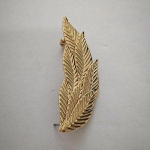 Detailopname van gouden metalen blad oorbellen met realistische geaderde textuur