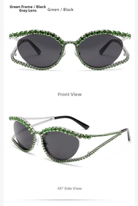 Macro shot of Y2K cat-eye sunglasses with green rhinestone frame and dark grey lenses