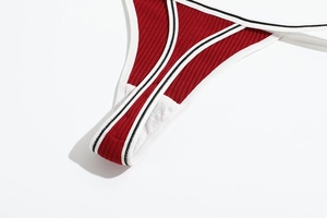 Close-up of red ribbed cotton fabric texture and black-white trimmed edge of the thong