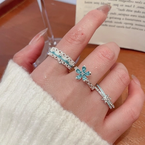 Three-piece set of silver rings featuring blue enamel flowers and sparkling zircon details