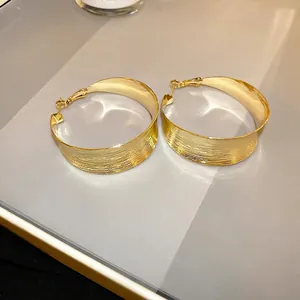 Elegant gold-plated large hoop earrings featuring a unique pleated texture finish