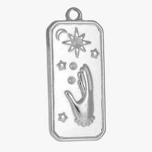 Détail d'un pendentif rectangulaire en acier argenté avec gravures soleil et lune