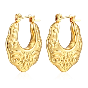 Detailed macro view of gold-plated hollow hoop earrings with vintage relief pattern