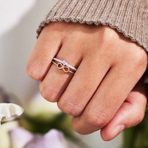 S925 sterling silver infinity ring and pink heart stone set worn on hand with knit background