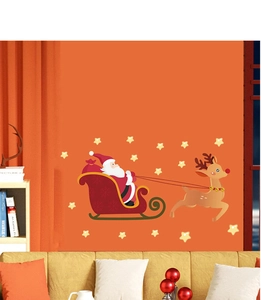 Detail of Christmas wall stickers with Santa, sleigh, and reindeer on an orange wall