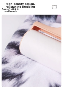 Close-up of pink lint roller removing pet hair and dust from black and white fabric