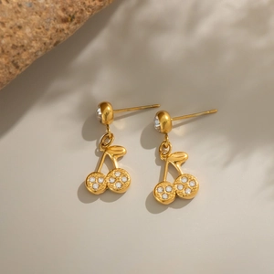 Detailed macro view of golden cherry stud earrings inlaid with sparkling rhinestones
