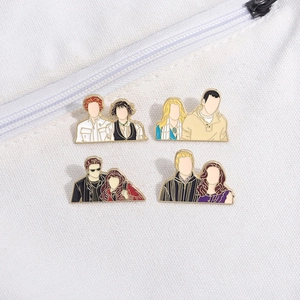 Detail of four faceless enamel pins featuring movie characters on white fabric bag