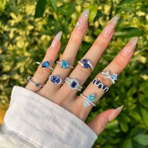 Detail of S925 silver rings with blue heart and pear-shaped zircon stones on hand