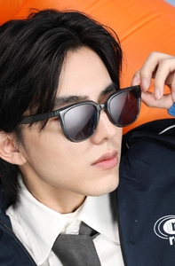 Close-up of stylish dark gray square sunglasses with translucent frames on a male model