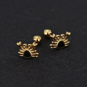 Detailed close-up of golden crab earrings with black enamel inlay and screw ball backs