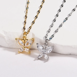 Détail de pendentifs papillon en or et argent sertis de pierres de zircone cubique