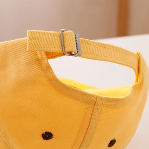 Vista dettagliata del cappellino da baseball giallo con fibbia posteriore regolabile