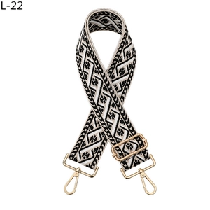 Detail view of ethnic geometric jacquard bag strap with gold metal hooks and buckle