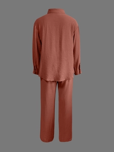 Detail of rust red two-piece lounge set showing crinkled fabric texture on back