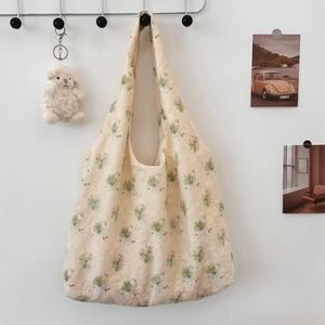 Close-up of delicate floral embroidery on light beige lace canvas tote bag with soft texture
