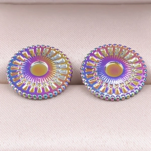 Macro shot of colorful round stud earrings with radial patterns on pink jewelry box liner