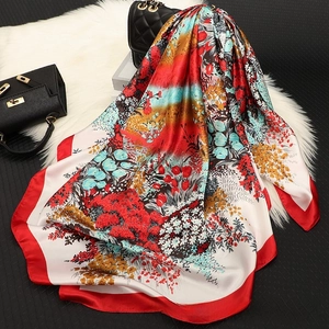 Detail shot of the silky satin floral scarf with vibrant digital prints and red borders