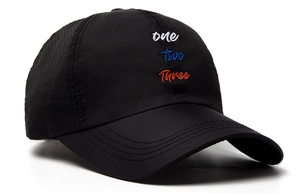 Detailed close-up of colorful letter embroidery and breathable mesh on black baseball cap