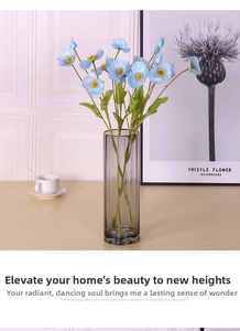 Light blue faux poppy flowers in a minimalist grey glass vase for home decor