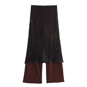 Detail of layered black lace skirt over brown wide-leg pants for elegant women style