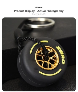 Close-up of racing tire keychain with gold wheel hub and yellow ZERO lettering detail
