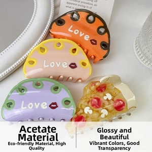 Detail of colorful acetate claw clips with Love lettering and pizza-shaped hair accessory