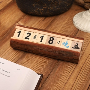 Calendrier minimaliste en blocs de bois avec date et jour sur une table rustique