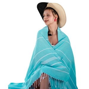Turquoise striped Turkish beach towel with fringe tassels worn as a summer shawl