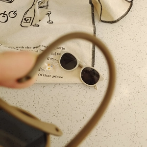 Detailed macro shot of vintage matte beige silicone kids sunglasses with dark round lenses