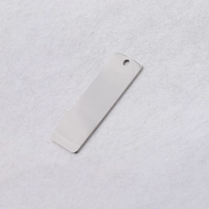 Close-up of a rectangular mirror-polished stainless steel pendant tag with a pre-drilled hole