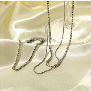 Vue détaillée du collier double chaîne serpent argentée et du bracelet tennis étincelant