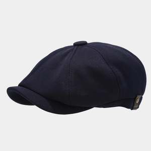 Classic navy blue newsboy cap with textured panels and side metal rivet detail