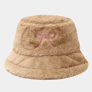 Détail d'un chapeau bob en peluche camel avec une broderie de nœud rose élégante