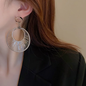 Close-up of model wearing silver hollow circle earrings with intricate wire-wrapped texture